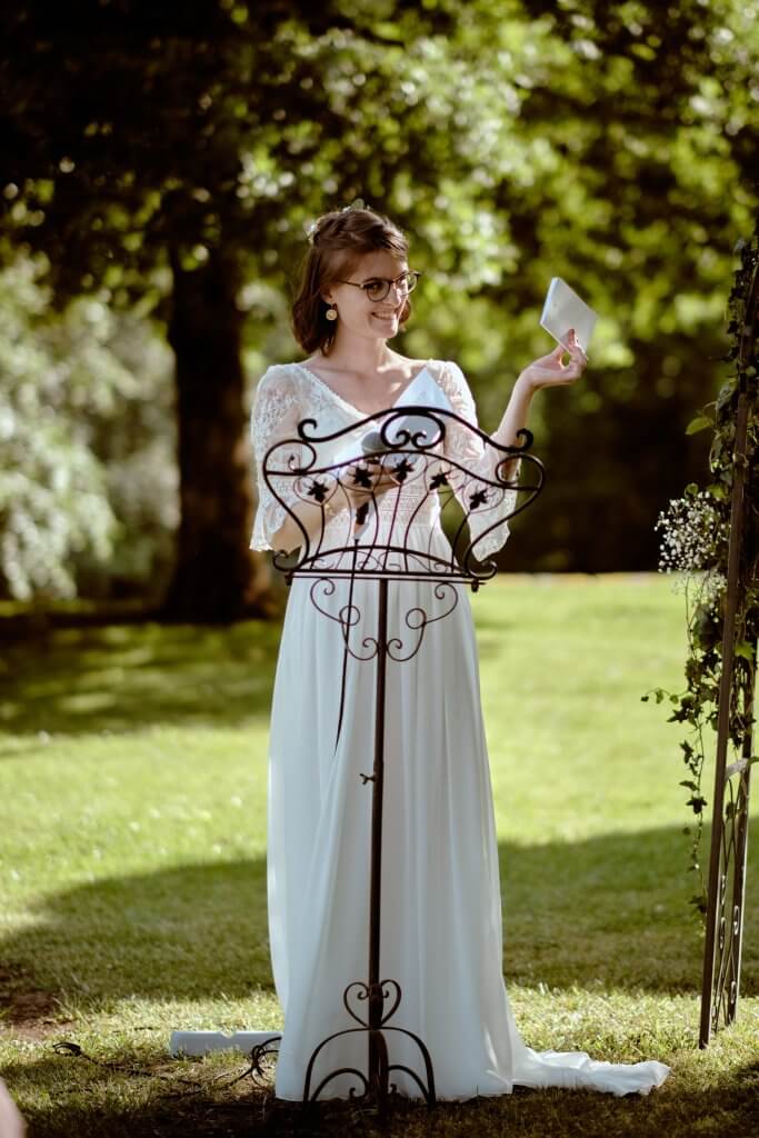 La mariée lit ses vœux au lutrin, dans le jardin du domaine
