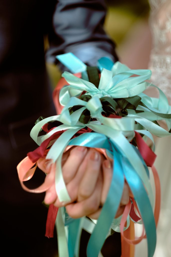 Les rubans de couleur noués autour du bouquet de la mariée