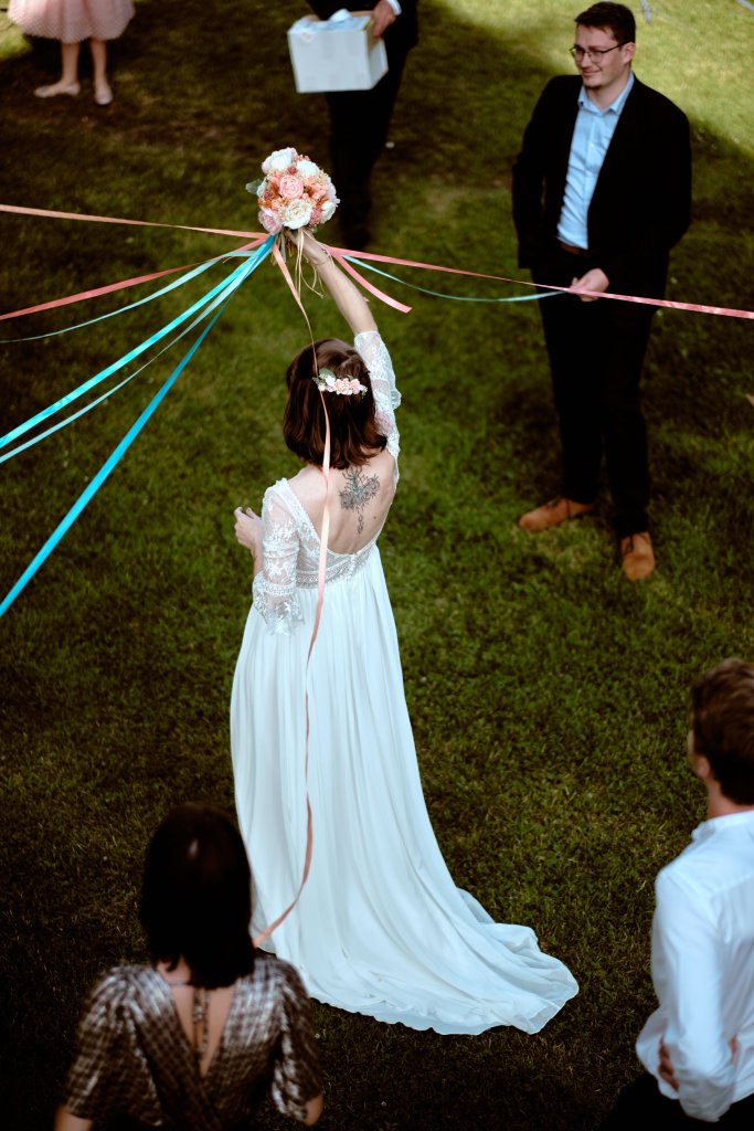 Le jeu des rubans : la mariée tient le bouquet à bout de bras