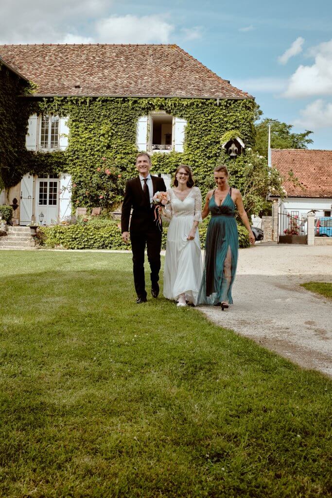 La mariée arrive au bras de ses deux parents