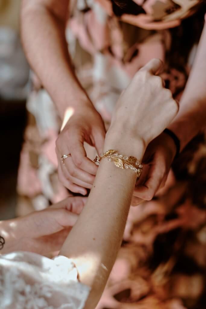 Un bracelet doré passé au poignet de la mariée par ses proches