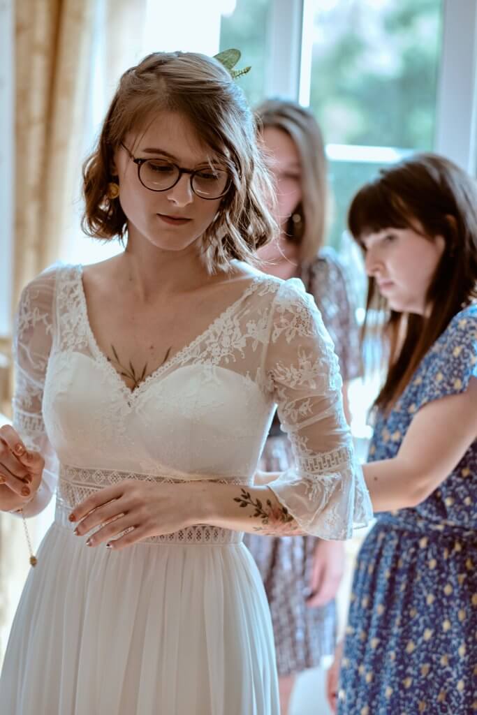 La mariée en robe de dentelle bohème, entourée de ses amies