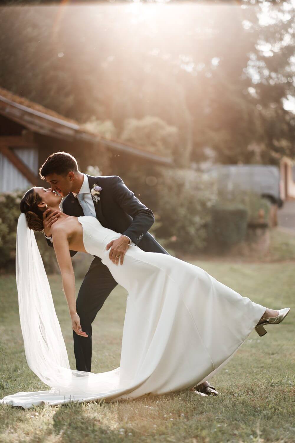 Mariage à Saverne : les mariés en contre-jour au coucher du soleil, la robe et le voile déployés
